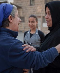 Sr Hala greets a woman who regularly attends JRS activities in Aleppo, Syria. (Jesuit Refugee Service)